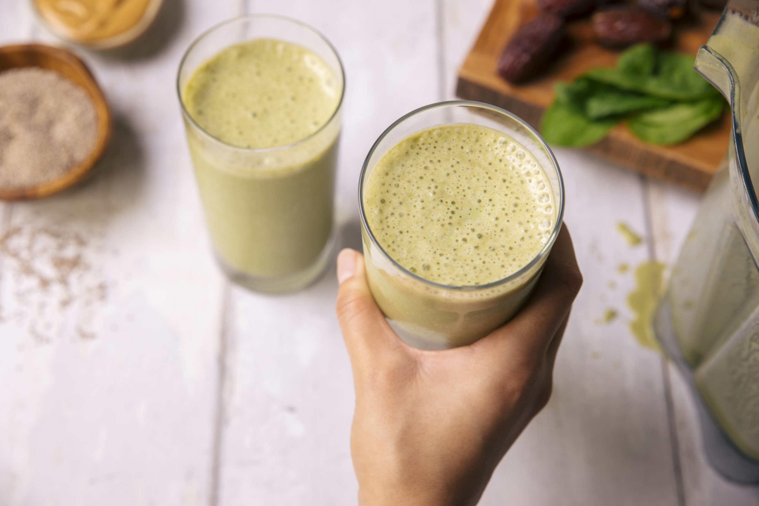 glasses of green protein smoothies on a white counter