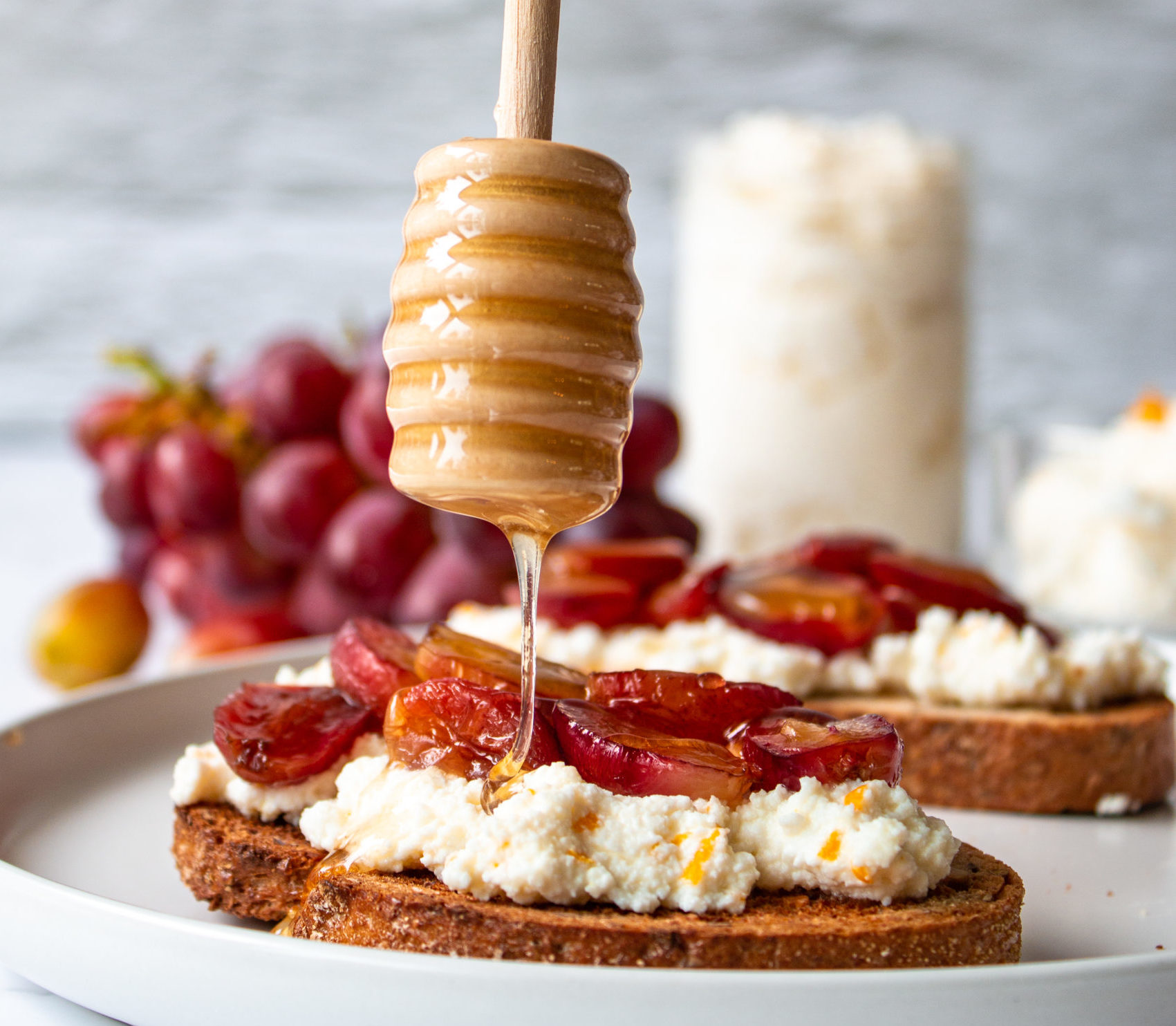 honey drizzled on ricotta toast with grapes
