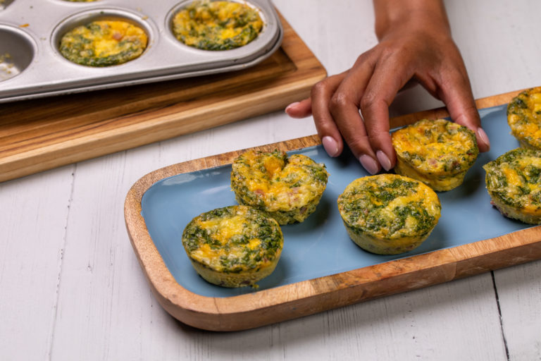 egg cheese muffin bites on blue tray and in muffin tins