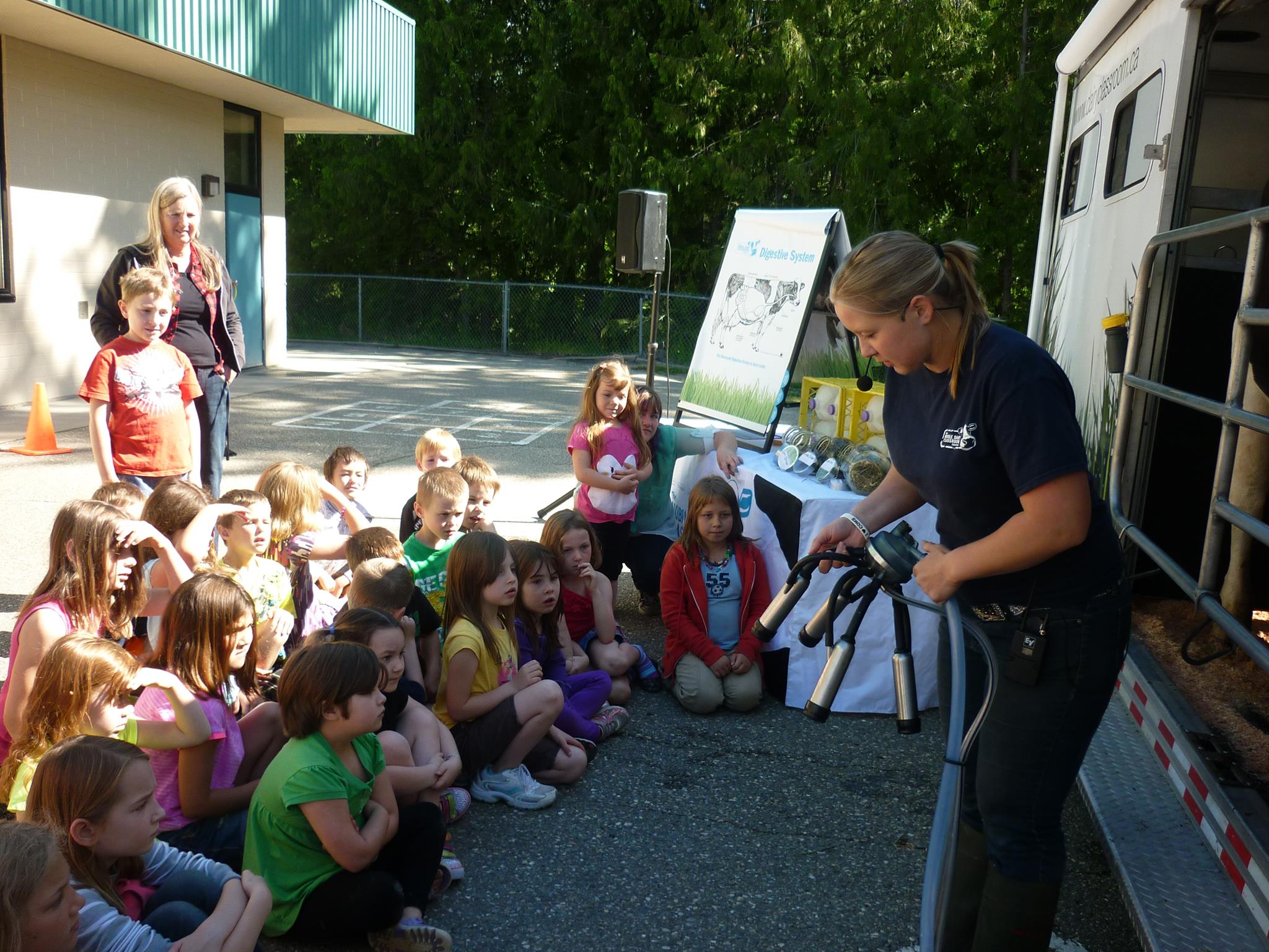 Mobile dairy classroom staff teaching kids about cow breeds.