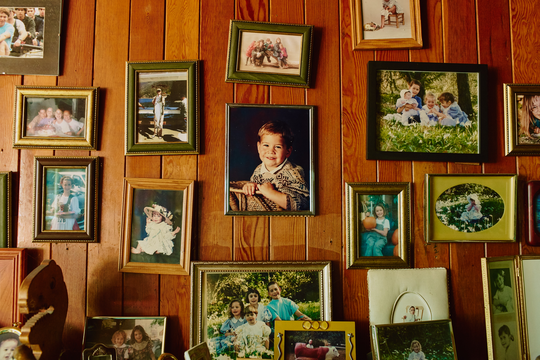 Wood panelled wall featuring a display of family photographs
