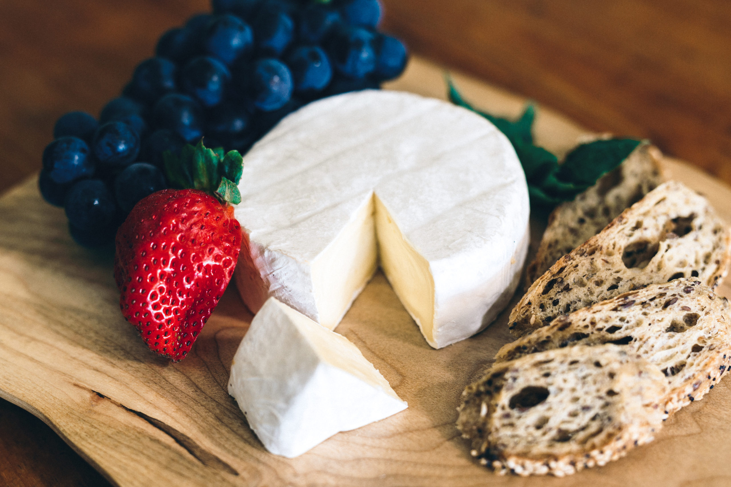 cheese wheel with bread and berries