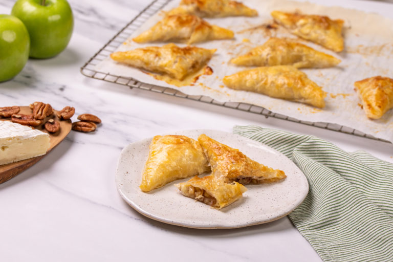 platter of brie turnovers with side of green apple, brie cheese, and pecans.