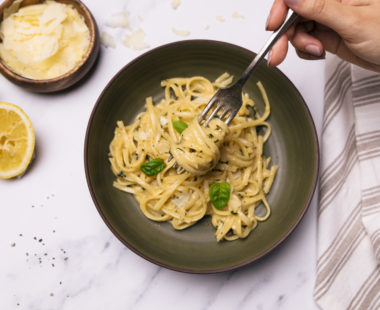 plate of pasta with side of parmesan cheese
