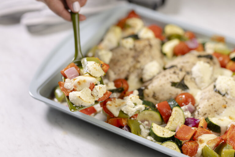 Cheese, chicken, and vegetable tray bake topped with ricotta and bocconcini.