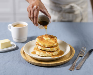 plate of pancakes drizzled with maple syrup