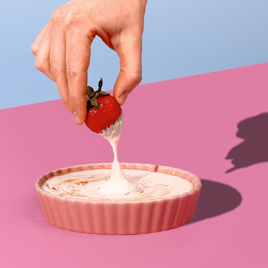 strawberry being dipped in cottage cheese fruit dip