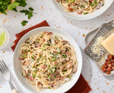 plate of pasta carbonara with a side of cheese and bacon