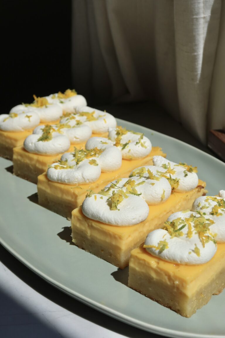 Citrus Shortbread Bars with Honey Whipped Cream on a plate on a counter