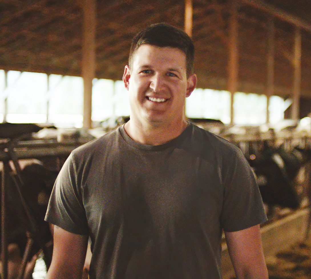 BC dairy farmer standing in barn